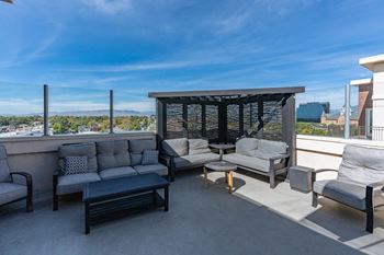 Patio with grey couches and a black table
